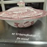 En engelsk kartoffelskål og låg af rød fajance, dekoreret med 1800-tals landidyl. Fin stand.