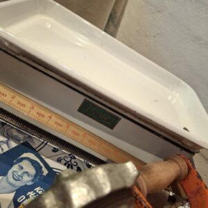 Nærbillede af en Vestas bagevægt med en hvid emaljeret skål og mærkatet 'Vestas' i grønt.