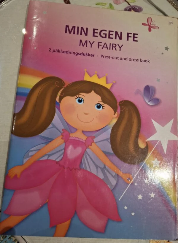 For- og bagside af 'Min egen fe' påklædningsbog. Forsiden viser en lyserød fe med krone.