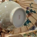 Undersiden af en kande med rød mærkning Made in Japan og en lys fodring.