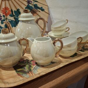 Vintage tesæt i perlemor med guldkant bestående af tekande, sukkerskål, flødekande og fire kopper med undertallerkener på et træfad.