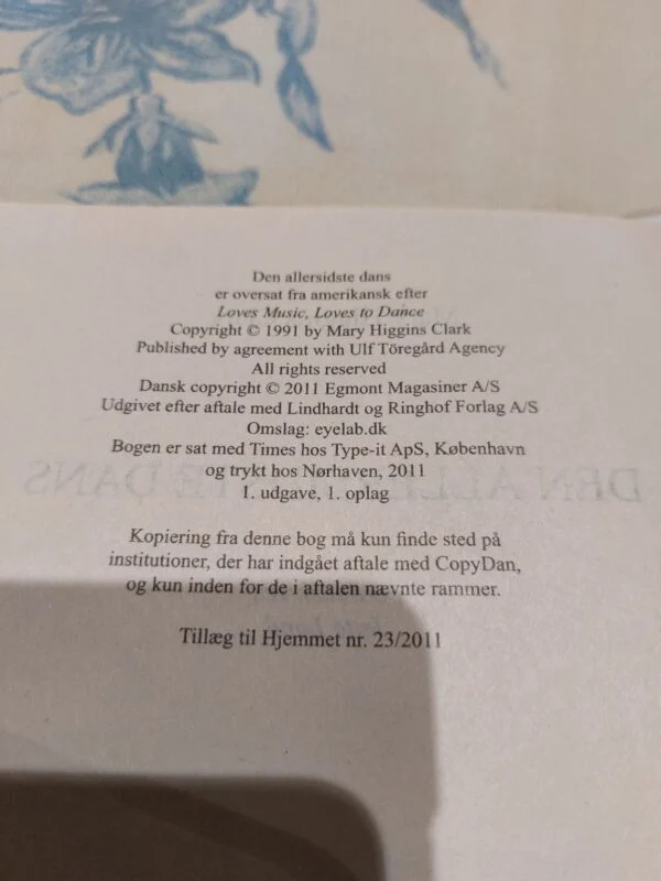 Et opslået side i bogen 'Den allersidste dans' af Mary Higgins Clark, med copyright- og udgiverinformation.