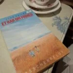 Forsiden af bogen 'Et råb om frihed' af John Briley, der viser to mænd i et gyldent græslandskab under en blå himmel.