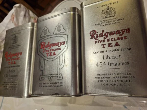 Tre blanke tedåser med Ridgways Five O’Clock Tea-tekst i rødt og sort, vist med låg.