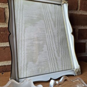 Nærbillede af en klar Holmegaard glasskål med blødt buede kanter og et synligt logo i bunden, placeret på et træbord.