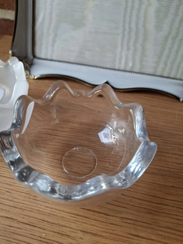 Nærbillede af en hjørnedetalje på en hvid vintage fotoramme med guldkant og ornamenteret metaludsmykning.