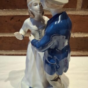 Højkvalitets porcelænsfigur af et dansende par. Manden i blå jakke, kvinden i hvid kjole, ansigterne tæt på hinanden.