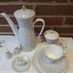 Et Rosenthal kaffesæt med kaffekande, sukkerskål, salt- og pebersæt samt en kaffekop og underkop. Alt i hvid porcelæn med gråt grafisk mønster.