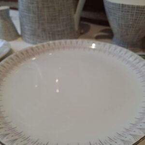 Bagsiden af en Royal Copenhagen jubilæumsplatte med det karateristiske stempel med tre bølger og 'Royal Copenhagen Denmark'.