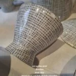En Rosenthal sukkerskål (eller bonbonniere) i hvid porcelæn med gråt grafisk mønster, set fra siden. Chippen er markeret med tekst.