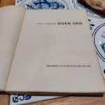 Nærbillede af forsiden på 'UDEN ORD' af Poul Strøyer, der fremhæver den ikoniske tegning og gule taleboble.