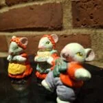 Middelstort foto af to musselmalede keramikmusefigurer. Den ene bærer blåt og orange tøj, den anden holder en kurv.
