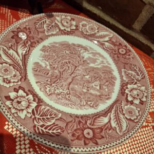 Rød transferware tallerken fra Wood & Sons England, 22 cm, med et detaljeret landskabsmotiv og blomsterkant.