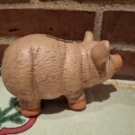 En terracotta sparegris set fra siden, der viser dens karakteristiske form og strukturerede overflade. På juledug.