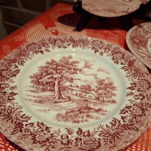 En klassisk rød transferware middagstallerken, 22 cm, fra W.H. Grindley i 'Country Style' med et landligt motiv.