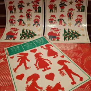 Tre ark med vintage selvklæbende juleklistermærker/vinduesfolie. To ark med nisser og et ark med røde silhuetter.