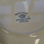 Nærbillede af bagsiden af et 'Victorian' fad fra Johnson Bros., hvor et blåt stempel med 'Victorian', 'JOHNSON BROS', 'MADE IN ENGLAND' og en krone er tydeligt synligt.
