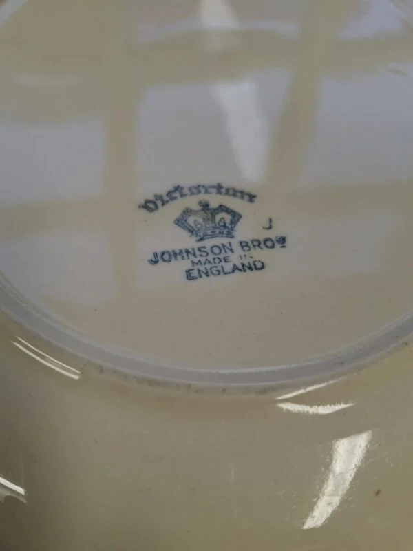 Nærbillede af bagsiden af et 'Victorian' fad fra Johnson Bros., hvor et blåt stempel med 'Victorian', 'JOHNSON BROS', 'MADE IN ENGLAND' og en krone er tydeligt synligt.