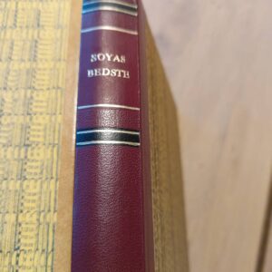 Sojas Bedste bog – Nærbillede af bogryggen i rødbrun med guldskrift og striber