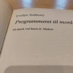 Titelblad med oversættelse for 'Programmeret til mord'