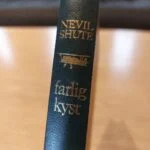 Bogryg 'Farlig Kyst' med flyillustration og guldpræg