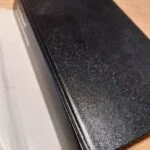 Sort hardcover bog med let patina