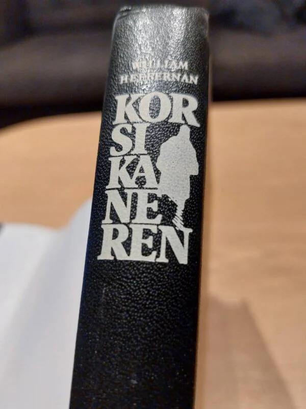 Sort bogryg med cremefarvet tekst og silhuet