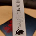 Bogryg med titel 'Swan' og sort svane på hvid baggrund