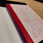 Lukket eksemplar af Signetringen med rødt, mønstret bind.