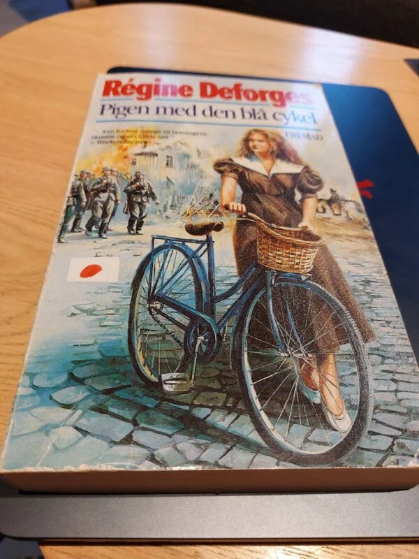 Illustreret forside af 'Pigen med den blå cykel' af Régine Deforges