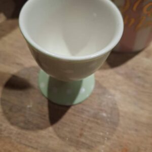 Grønt æggebæger med hvide prikker set forfra