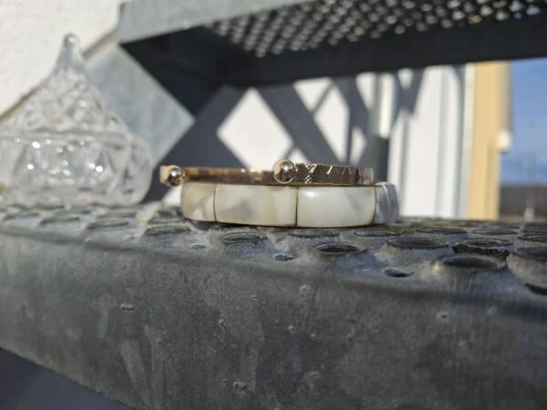 Retro armbånd og glasbeholder på metaltreppe