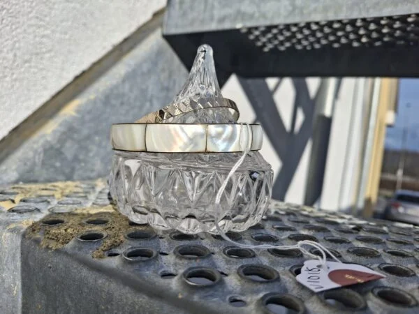 Armbånd og krystalglasbeholder på metaltreppe
