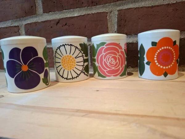 Fire krukker med farverige blomsterdesigns