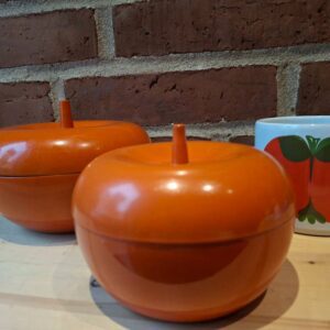 Sæt af to retro orange æbledåser fra Lønborg Denmark med en kop i baggrunden