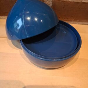 Blå beholder med låg og bordskånere på træbord