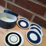 Blå holder med seks coastere i retrodesign på træbord
