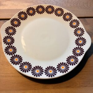 Retro fad med blomstermønster og brune orange blomster på træbord