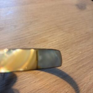 Retro armbånd med gyldne toner på træbord