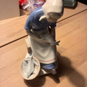 Porcelænsfigur af fiskerkone med fisk i kurv på bord