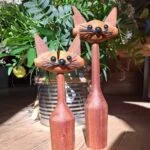 To vintage trækattefigurer i varm træfarve med detaljerede ansigter og spidse ører