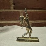 Messingfigur af jomfru på beige klæde