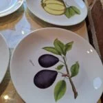 To porcelænstallerkener med frugtillustrationer: blommer og kvæde