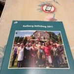 Forsiden af Aalborg Stiftsbog 2011 med gruppefoto foran en kirke