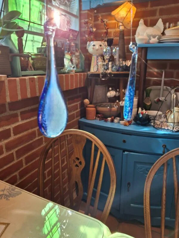 Detaljebillede af blå glasdråber med sollys