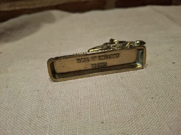 Bunden af messingfigur med 'Made in England'