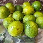 Nærbillede af glasopsats fyldt med limefrugter