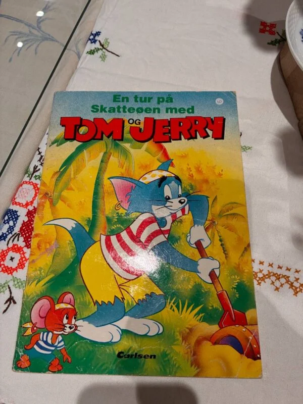 Forside af børnebogen 'En tur på Skatteøen med Tom og Jerry' med farverige illustrationer