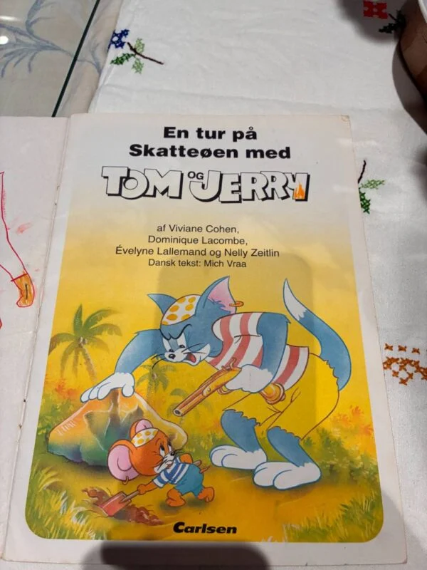 Titelbladet af 'En tur på Skatteøen med Tom og Jerry' med forfattere og illustration