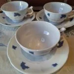 Hvide kaffekopper med blåt blomstermønster og underkopper, set forfra